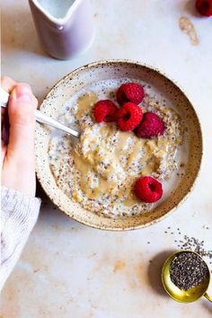 a bowl of oatmeal with raspberries and chia seeds on the side