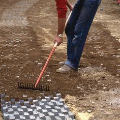 a man is digging in the dirt with a shovel and some sort of tile on the ground