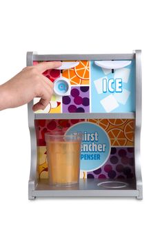 a person holding a drink in front of an ice box with different pictures on it