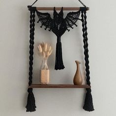 a wooden shelf with two vases and a black tassel hanging from it's side