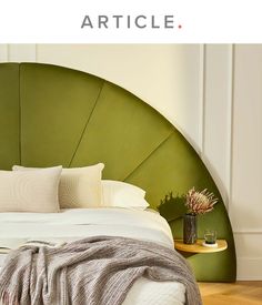 a green headboard with white pillows and blankets on it in front of a bed