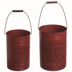 two red metal buckets with merry and bright written on the side, one holding a handle