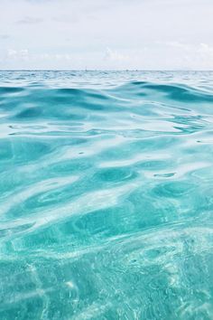 the water is very clear and blue with little waves on it's surface in the ocean