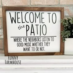 a wooden sign sitting on top of a white mantle next to a potted plant