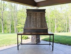 an outdoor fireplace with a table underneath it