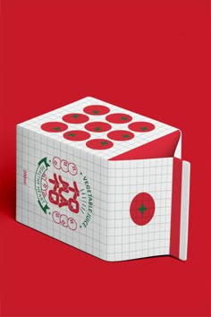 a white box with red and green stickers on the side, sitting on a red background