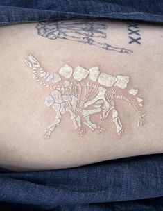 a close up of a person's arm with tattoos on it and a skeleton in the shape of a horse