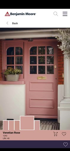 a pink front door with some plants in the window