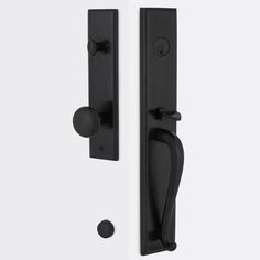 two black door handles and knobs on a white wall