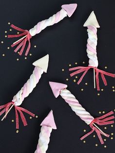 pink and white candy sticks with bows on them are arranged in the shape of stars