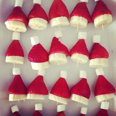 strawberries and bananas are arranged in santa hats on skewers with marshmallows