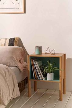 a bed room with a neatly made bed and a night stand on the side table