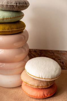 a stack of pillows sitting on top of a wooden table next to a pillow case