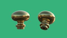 two shiny gold knobs on a green background