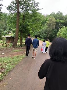 a group of people walking down a dirt road