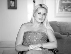 black and white photograph of a woman sitting in a chair with her hands on her knees