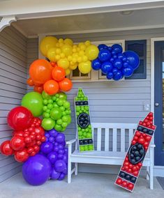 a bunch of balloons that are on the side of a house with a bench in front of it