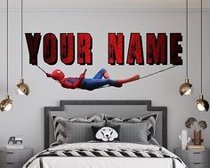 a bedroom with a spiderman wall decal above the bed