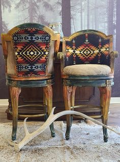 two wooden chairs sitting next to each other on top of a rug