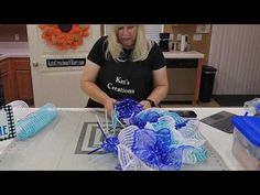 a woman is making blue and white streamers out of plastic bottles on a table