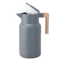 a gray jug with a wooden handle and lid is shown on a white background,