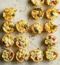 small appetizers are arranged in rows on a white surface with sprinkles