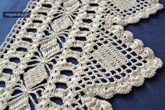 crocheted doily is laying on a blue tablecloth with white trimmings