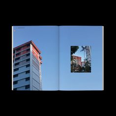 an open book with the image of two buildings in front of blue sky and trees