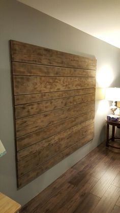 a bed room with a neatly made bed and a wooden headboard on the wall