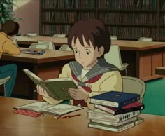 a young boy sitting at a table with books in front of him