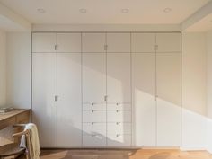 an empty room with white cabinets and wooden floors