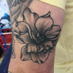 a woman's arm with a flower tattoo on it