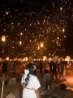 many people are flying lanterns in the sky