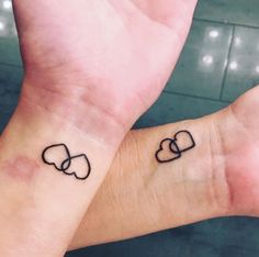 two people with matching tattoos on their wrists