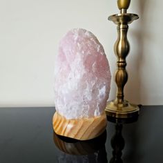 a pink rock sitting on top of a table next to a candle