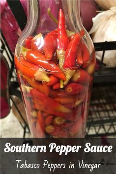 a glass vase filled with red peppers on top of a counter