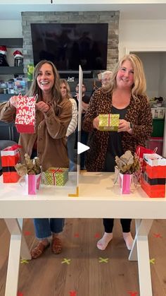 two women holding up presents at a table