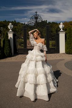 a woman in a white dress is standing outside