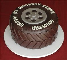 a birthday cake made to look like a tire on top of a red tablecloth