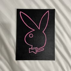 a black and pink drawing of a rabbit's head on a white bed sheet