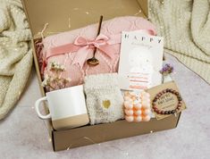 an open box with some items in it on a table next to pillows and blankets