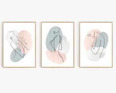 three framed art pieces with different shapes and colors on the same wall, one in grey, one in pink