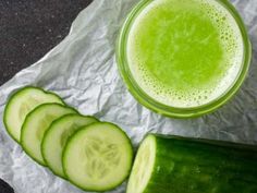 cucumber slices next to a glass of green liquid