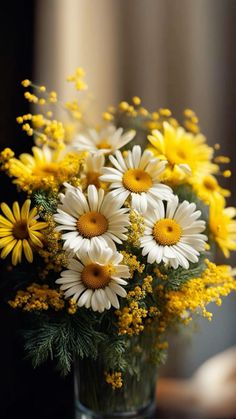 a vase filled with lots of yellow and white flowers