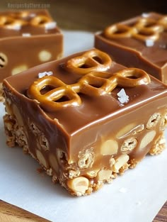 two pieces of chocolate covered pretzel bar sitting on top of a piece of paper