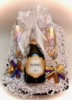 a bottle of korbel wine in a gift box with candles and confetti