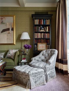 a living room filled with furniture and a book shelf next to a chair in front of a window