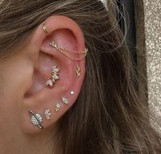 a close up of a person's ear with multiple piercings on top of it