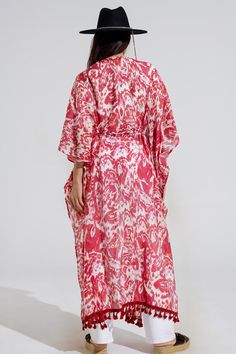 Introducing our enchanting Red Long Kimono with Drawstring Closing in Tribal Print, a must-have piece for your summer wardrobe. This maxi-length kimono features a captivating tribal print that adds a touch of bohemian flair to any ensemble.  Crafted from a lightweight chiffon fabric blend of 70% viscose and 30% polyamide, this kimono is perfect for layering over your favorite swimsuit as a stylish beach cover-up. The 3/4 length sleeves and relaxed fit ensure comfort and ease of movement, while the drawstring closing adds a customizable touch to your look.  Complete with fringe trim details at the bottom, this kimono exudes casual elegance with a hint of boho-chic charm. Whether you're lounging by the pool or strolling along the beach, this kimono is sure to keep you looking effortlessly st