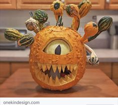 an orange pumpkin decorated to look like a monster's head with teeth and eyes